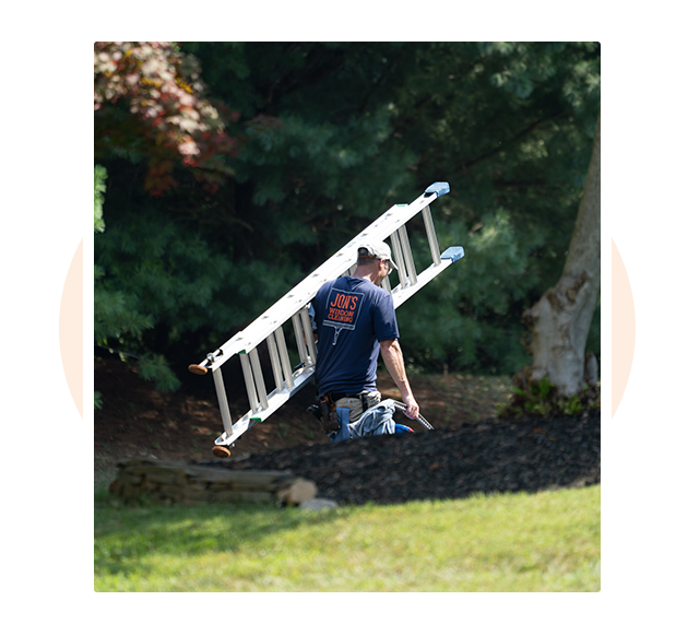 Professional window cleaners carrying ladders and climbing high to clean residential windows in Downingtown, PA — fully trained and insured team