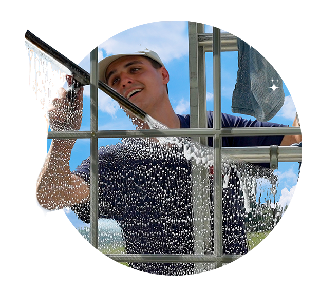 Professional residential window cleaner on ladder using squeegee for streak-free, crystal-clear windows in Downingtown, PA