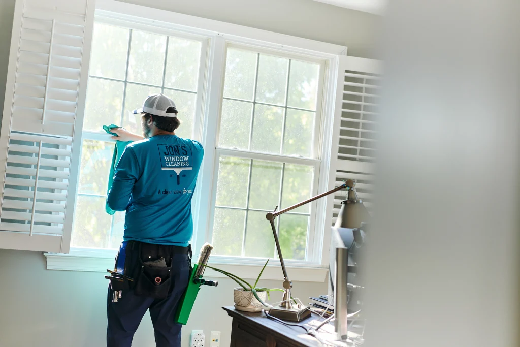 House window washing crew professionally cleaning exterior glass and residential windows