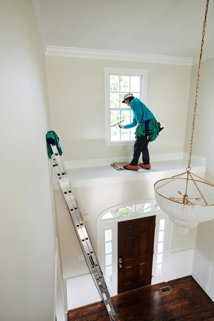 Professional interior window cleaning for hard-to-reach windows above a residential entryway