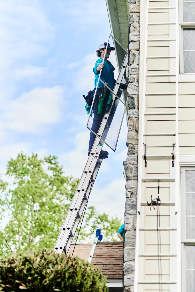 Residential exterior window cleaners professionally washing windows on a family home