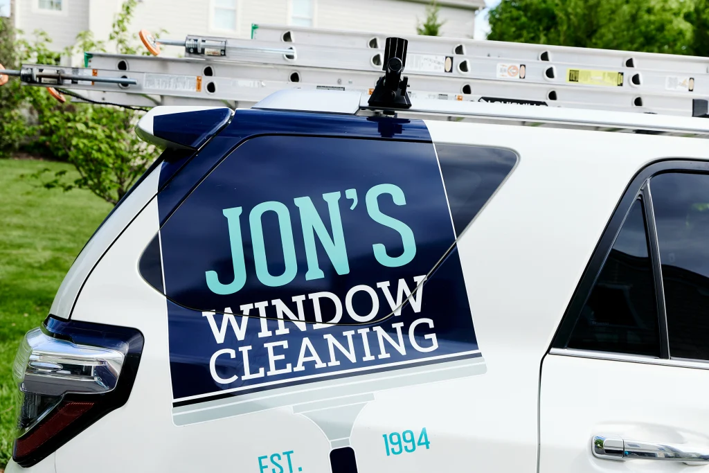 Residential window washing service cleaning exterior glass on a family home