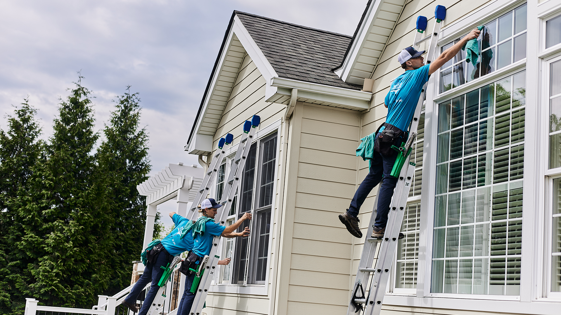 Residential window cleaning team in Chester County PA using ladders to professionally clean exterior home windows